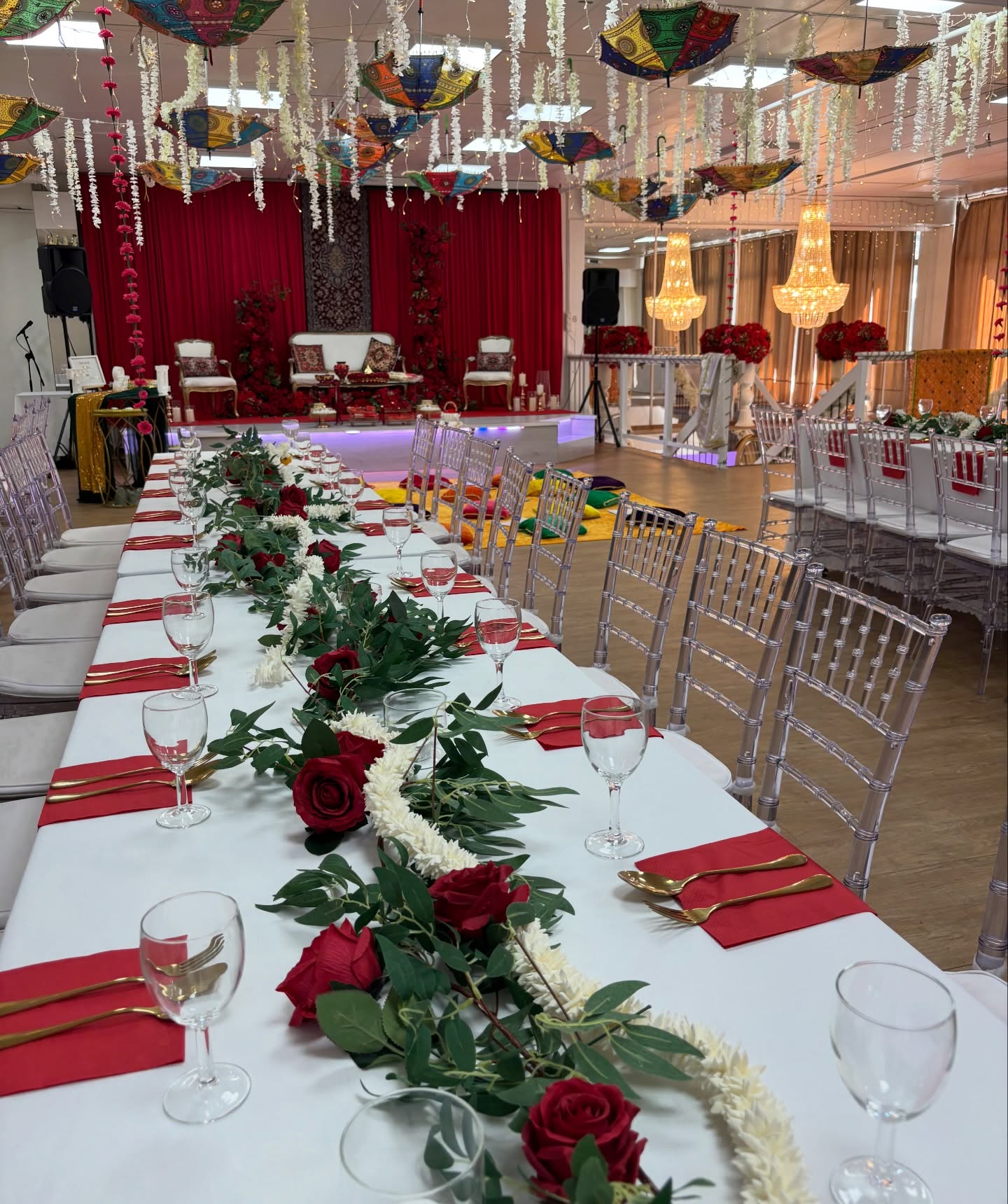 Langbord med rosegirlander, gullbestikk og hengende parasoller